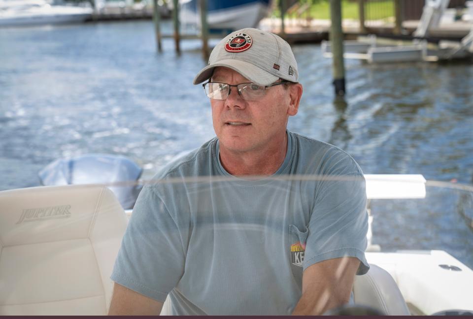 Homeowner Mitch Huhn drives his boat along the waterway where he lives in the Paradise Port community in Palm Beach Gardens.