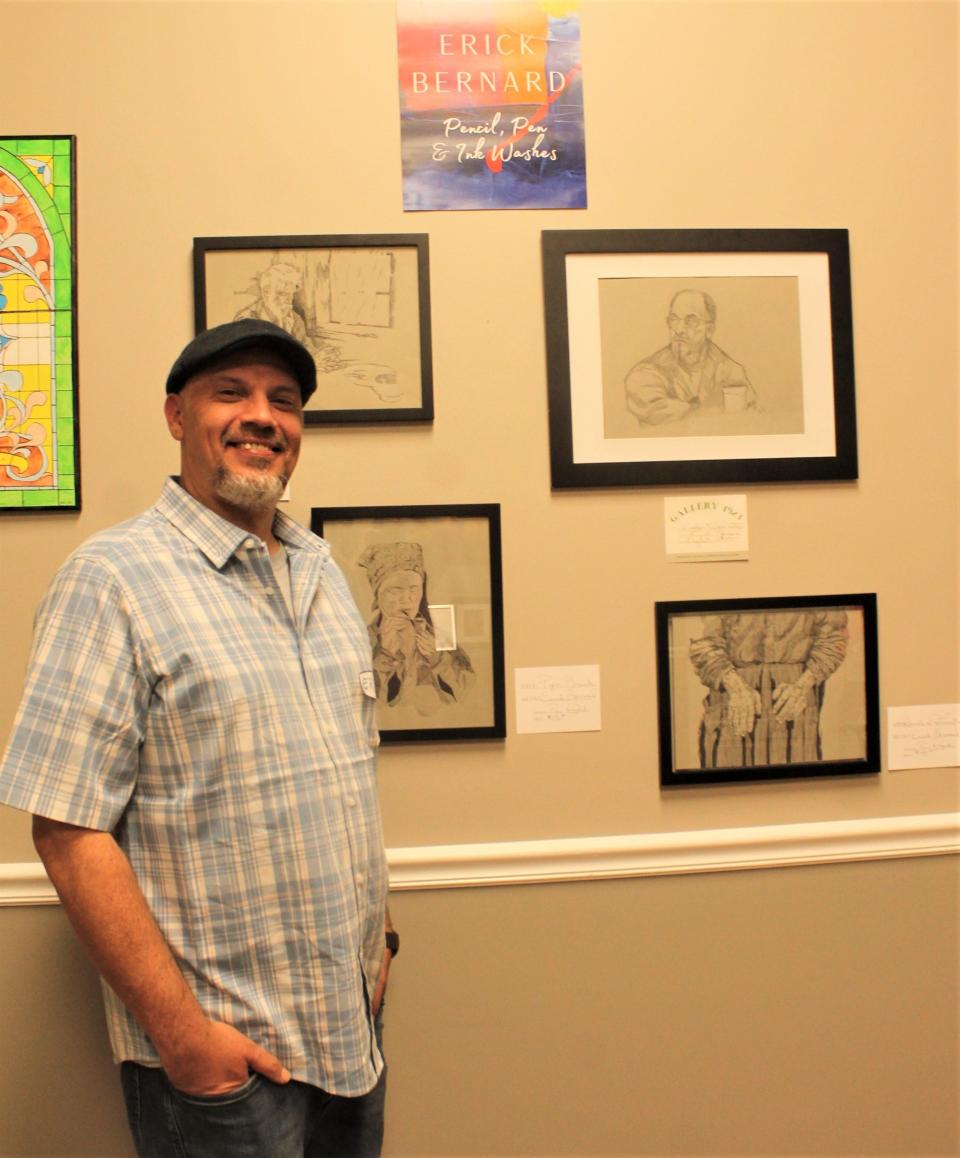 Erick Bernard poses with his work on display at Gallery 1923 in Louisville.