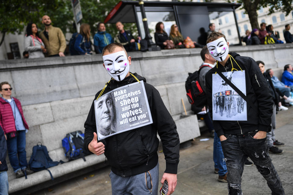 Two men wearing masks are seen at the protest.