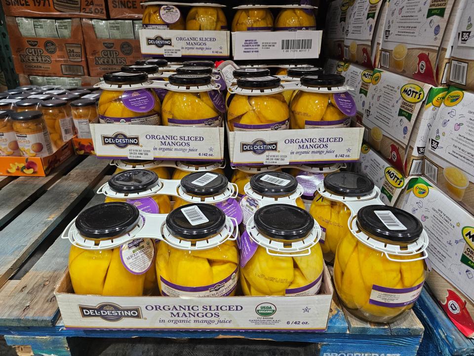 Slices of mango in glass jars on Costco pallette