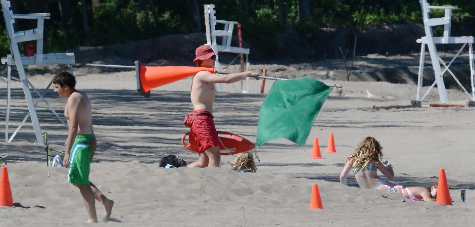 Presque Isle State Park lifeguard Owen Hardner, 18, center, helps open Beach 6 for swimming in Millcreek Township on June 24, 2022. Hardner is in his third season as a guard at the park.