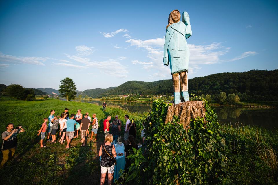 TOPSHOT - People gather around what conceptual artist Ales 'Maxi' Zupevc claims is the first ever monument of Melania Trump, set in the fields near the town of Sevnica, US First Ladys hometown, during a small inauguration celebration on July 5, 2019. - After Melania cake, Melania honey, and even Melania slippers, the Slovenian hometown of the US's first lady will now boast a statue of its most famous daughter -- albeit one which has faced decidedly mixed reviews. The life-size statue on the outskirts of Sevnica was inaugurated on July 5, 2019. (Photo by Jure Makovec / AFP) / RESTRICTED TO EDITORIAL USE - MANDATORY MENTION OF THE ARTIST UPON PUBLICATION - TO ILLUSTRATE THE EVENT AS SPECIFIED IN THE CAPTION        (Photo credit should read JURE MAKOVEC/AFP/Getty Images)