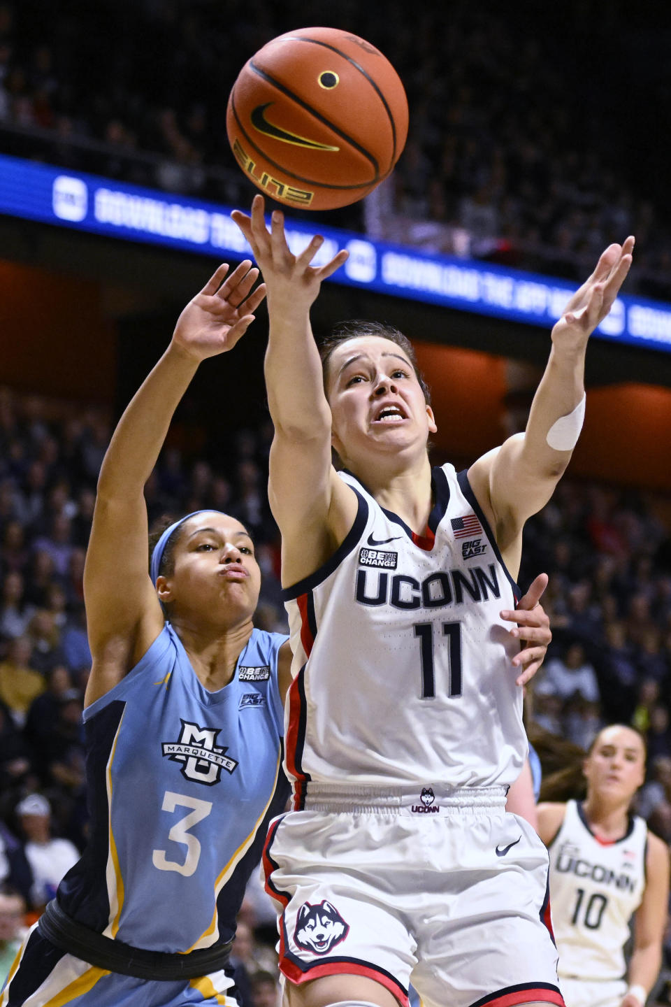 Marquette's Rose Nkumu (3) and UConn's Lou Lopez Senechal (11) reach for the ball during the second half of an NCAA college basketball game in the semifinals of the Big East Conference tournament at Mohegan Sun Arena, Sunday, March 5, 2023, in Uncasville, Conn. (AP Photo/Jessica Hill)