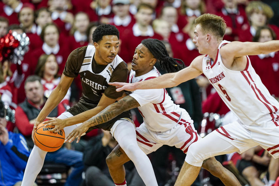 Wisconsin's Kamari McGee, center, Tyler Wahl reach in on Lehigh's Evan Taylor (5) during the second half of an NCAA college basketball game Thursday, Dec. 15, 2022, in Madison, Wis. Wisconsin won 78-56. (AP Photo/Andy Manis)