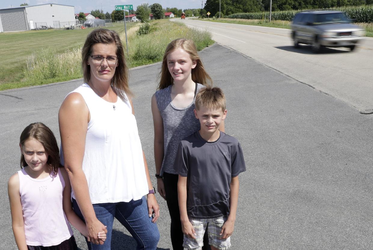 Jodie Skadahl and her children, Zoe, left; Kat, center right; and Cody at the location of their new bus stop between Oshkosh and Winneconne.