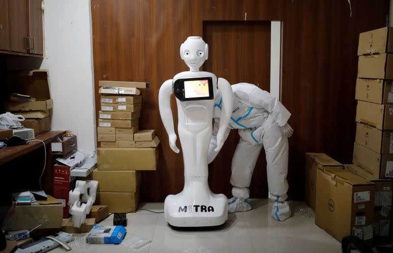 A medical worker puts robot named 'Mitra' , which is used by the patients suffering from the coronavirus disease (COVID-19) to communicate with their relatives, on charge at a Hospital in Noida