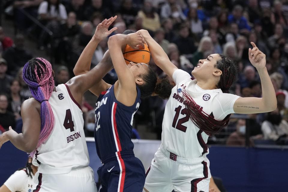 South Carolina's Aliyah Boston and Brea Beal stop UConn's Evina Westbrook during the second half of a college basketball game in the final round of the Women's Final Four NCAA tournament Sunday, April 3, 2022, in Minneapolis. (AP Photo/Charlie Neibergall)