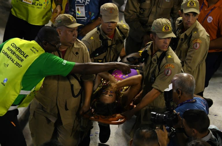 Firefighters assist a reveller of the Unidos da Tijuca samba school at the Sambadrome in Rio de Janeiro early on February 28, 2017, after the third floor of an allegorical car collapsed during the second night of Rio Carnival