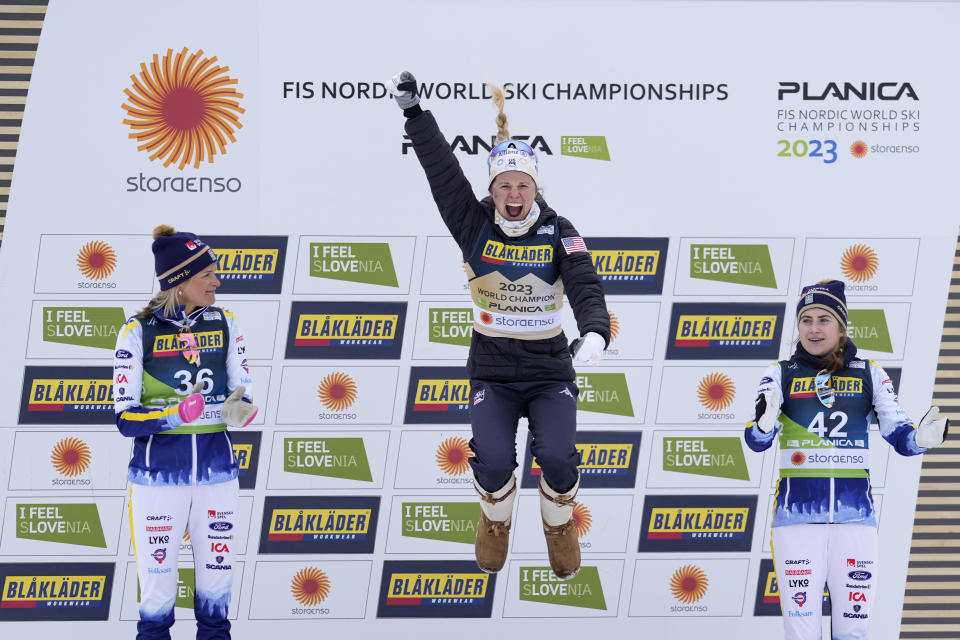 Jessie Diggins, of the United States, celebrates on the podium after winning the Women's Cross Country Interval Start 10 KM Free event at the Nordic World Championships in Planica, Slovenia, Tuesday, Feb. 28, 2023. At left is silver medalist Frida Karlsson, of Sweden, and at right bronze medalist Ebba Andersson, also of Sweden. (AP Photo/Matthias Schrader)