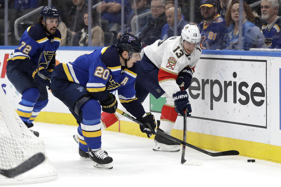 St. Louis Blues' Alexander Steen (20) and Florida Panthers' Mark Pysyk (13) chase after a loose puck along the boards as Blues' Justin Faulk (72) watches during the first period of an NHL hockey game Monday, March 9, 2020, in St. Louis. (AP Photo/Jeff Roberson)