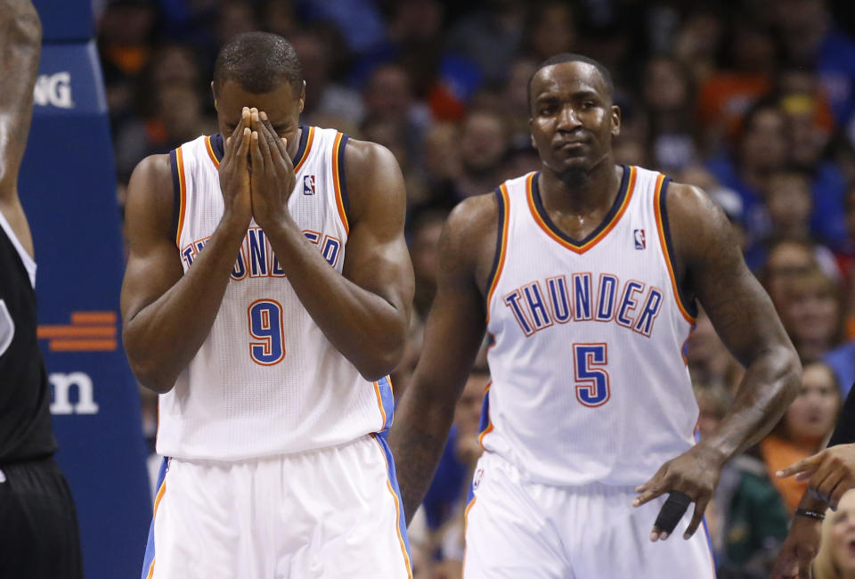 Oklahoma City Thunder forward Serge Ibaka (9) reacts after being called for offensive interference in the second quarter of an NBA basketball game against the Sacramento Kings in Oklahoma City, Sunday, Jan. 19, 2014. Thunder center Kendrick Perkins (5) looks on. (AP Photo/Sue Ogrocki)