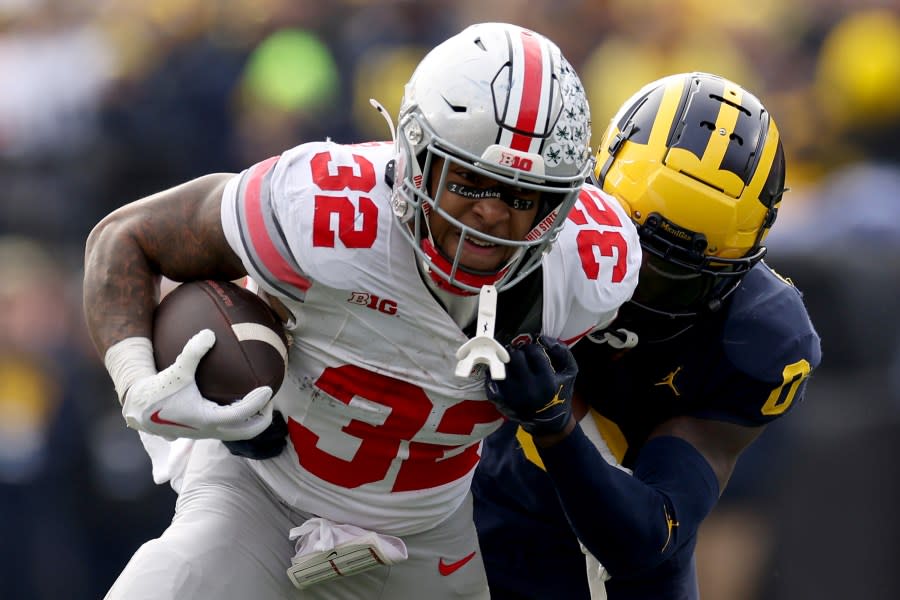 ANN ARBOR, MICHIGAN – NOVEMBER 25: TreVeyon Henderson #32 of the Ohio State Buckeyes runs with the ball against Mike Sainristil #0 of the Michigan Wolverines during the second quarter in the game at Michigan Stadium on November 25, 2023 in Ann Arbor, Michigan. (Photo by Ezra Shaw/Getty Images)