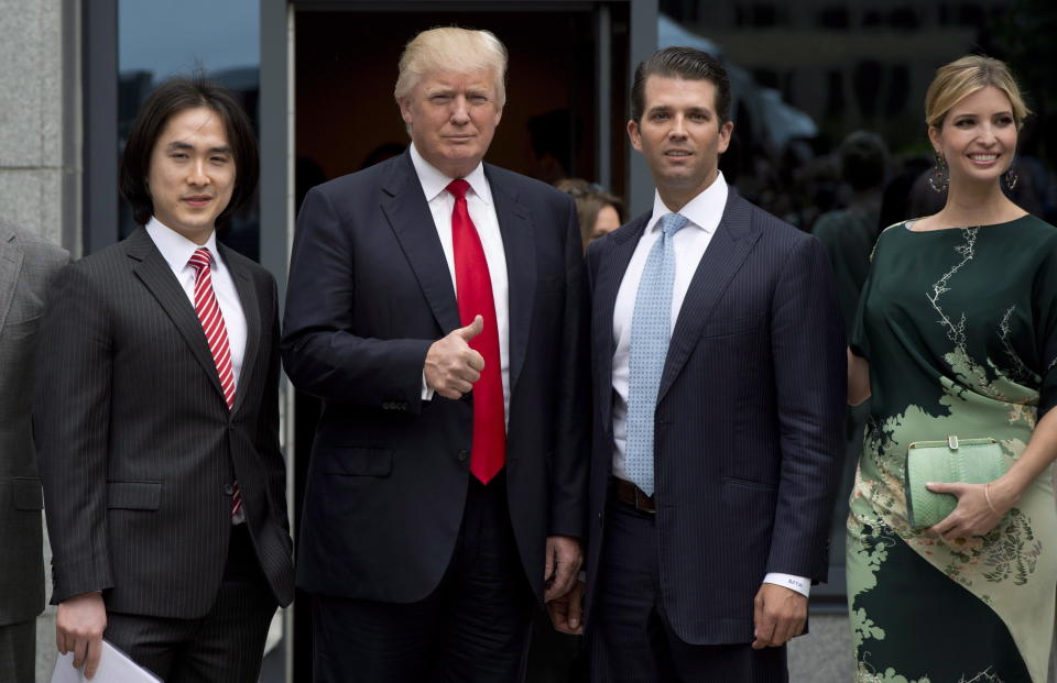 In this June 19, 2013 photo, Donald Trump, center, gives the thumbs up as he arrives with son Donald Trump Jr., daughter Ivanka Trump and Joo Kim Tiah, CEO and president of Holborn Group, to announce the building of Trump International Hotel and Tower Vancouver in downtown Vancouver, British Columbia, Canada. The 69-story tower has drawn praise for its sleek, twisting design. Prices for the condominiums have set records. But the politics of President Donald Trump have caused such outrage that the mayor won’t attend the Feb. 28 grand opening and has lobbied for a name change. (Jonathan Hayward/The Canadian Press via AP)