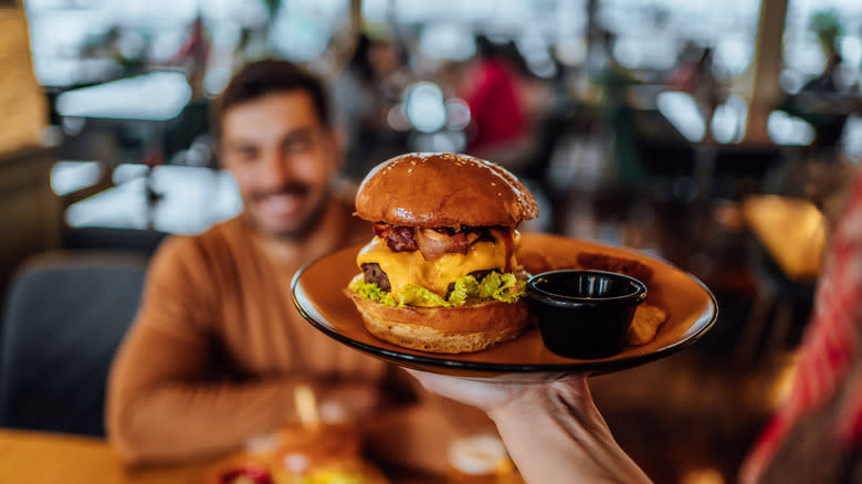 couple eating hamburger in restaurant