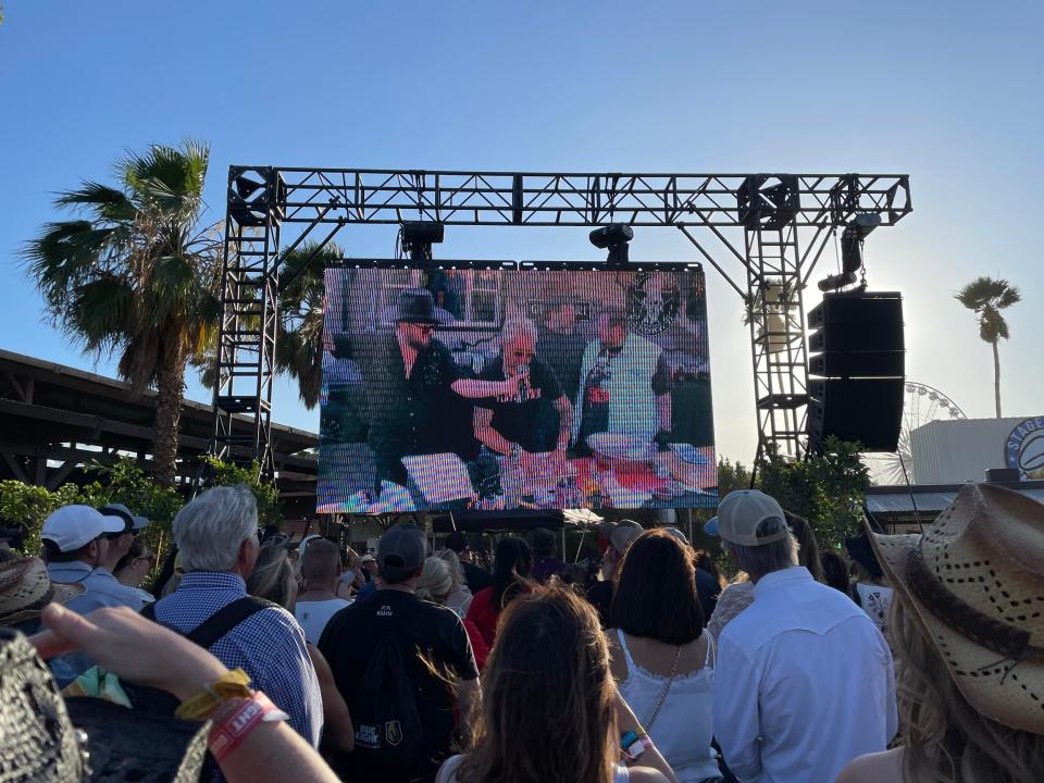 Guy Fieri, middle, rolls up the jelly roll meal he prepared with performers Paul Cauthen, left, and Jelly Roll on Friday at the Stagecoach country music festival.