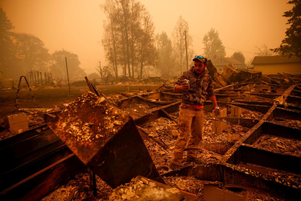 Kraig Arndt of Mill City takes photos of a friend's home that burned to the ground during the Labor Day fires in September 2020 in Mill City.