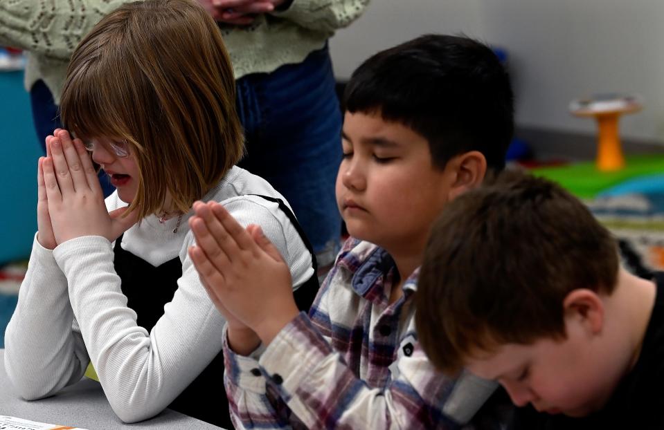 Maggie Reynen, left, Jaxon Truell and Benton Lill pray in the Sunday school class of Kelsey 
Elliott, the children’s pastor at Waverly Church of the Nazarene on Sunday, March 24, 2024, in Waverly, Tenn. The church’s original building on East Main Street was flooded during torrential flash flood that killed 20 people in 2021.