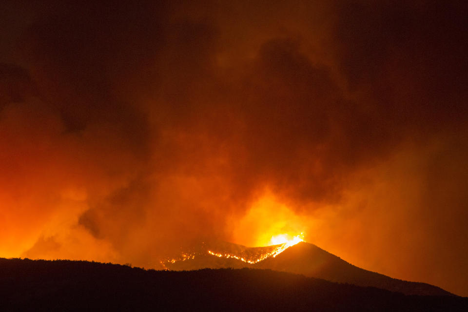 A brush fire burns at the Apple Fire in Banning, Calif., Saturday, Aug. 1, 2020. (AP Photo/Ringo H.W. Chiu)