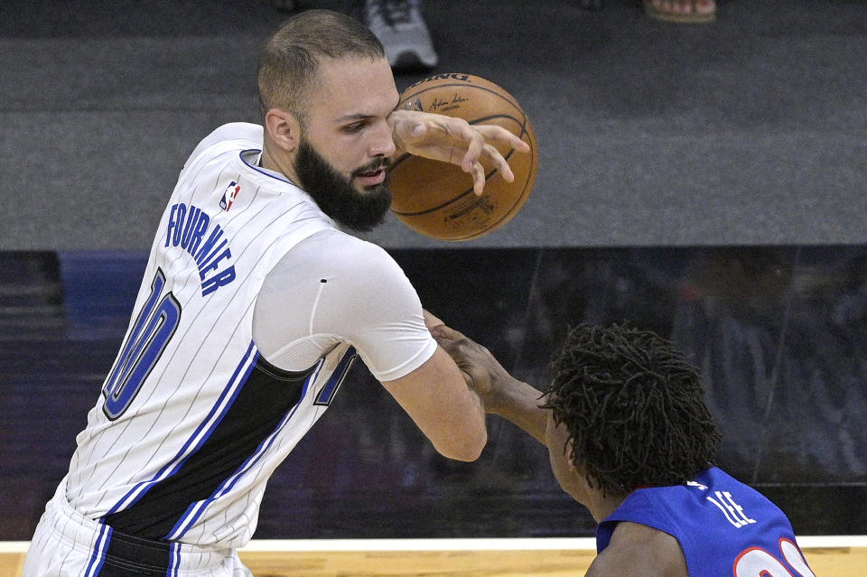 Orlando Magic guard Evan Fournier, left, is fouled by Detroit Pistons guard Saben Lee, right, while setting up for a shot during the second half of an NBA basketball game, Tuesday, Feb. 23, 2021, in Orlando, Fla. (AP Photo/Phelan M. Ebenhack)
