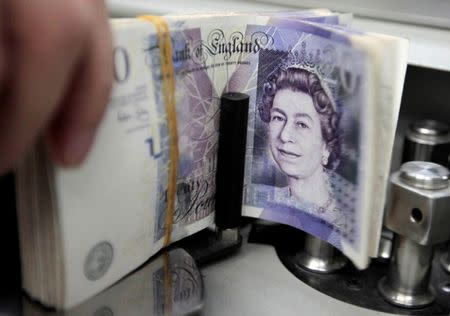 A bank employee counts pound notes at Kasikornbank in Bangkok, Thailand, October 12, 2010. REUTERS/Sukree Sukplang/File Photo