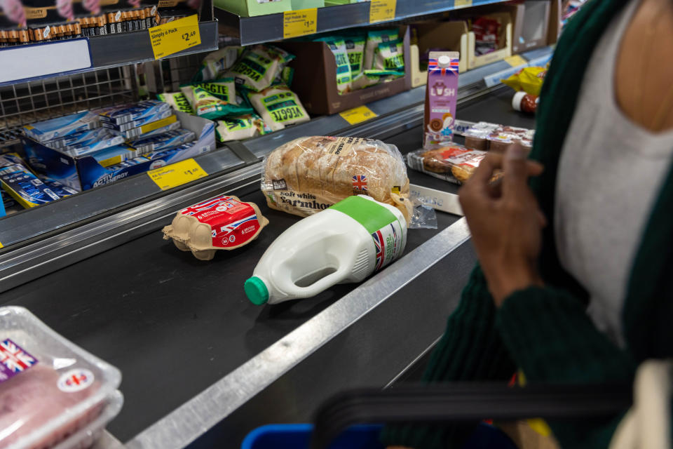 Close up of shopping on a conveyor belt.  Food and eating out costs drive fall in inflation