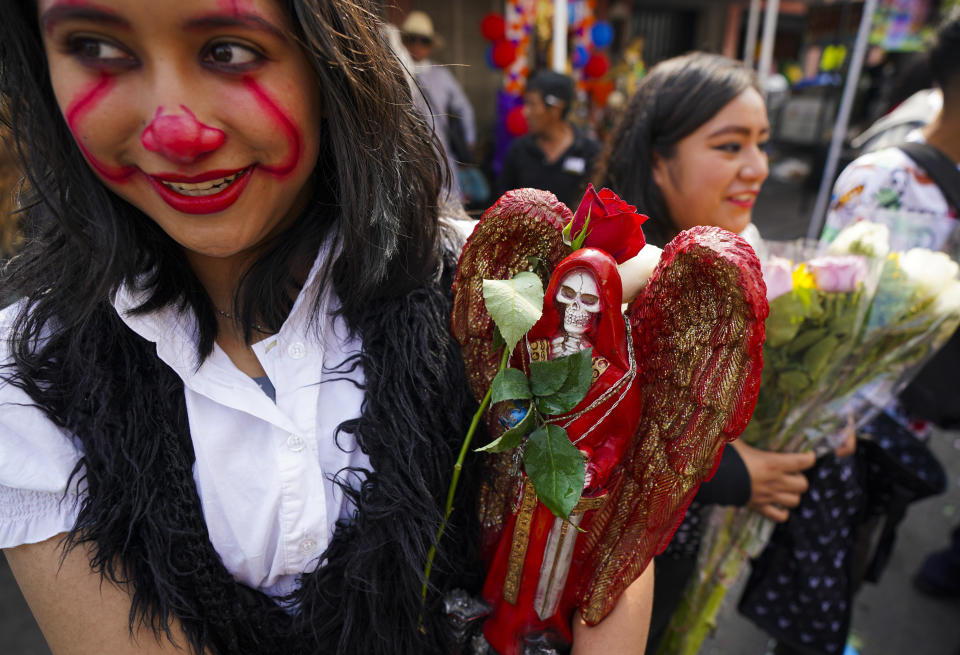 Una creyente sostiene una estatua de "La Santa Muerte", en el barrio de Tepito de la Ciudad de México, el martes 1 de noviembre de 2022. La Santa Muerte es una imagen de culto y un santo popular, una personificación de la muerte, asociada con la curación, la protección y la entrega segura al más allá por parte de sus devotos. (AP Foto/Fernando Llano)