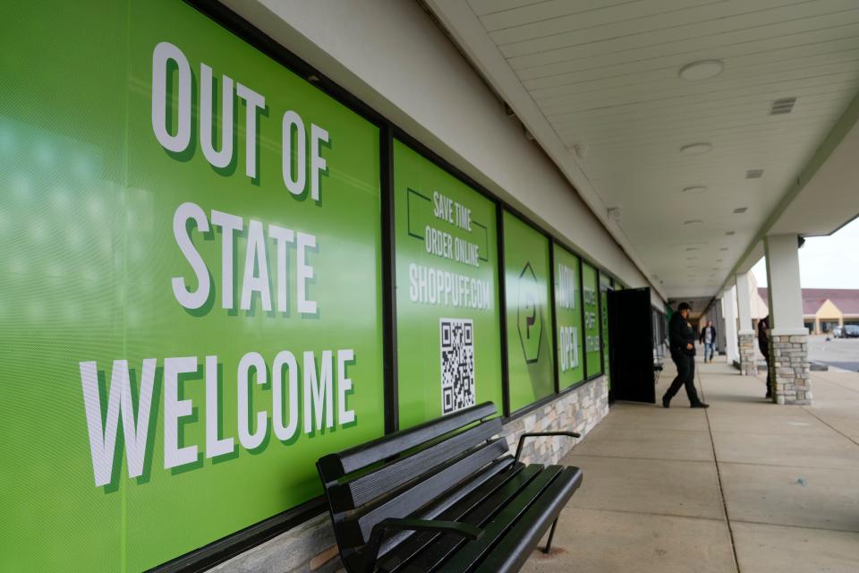 A sign welcomes out-of-state customers to Puff Cannabis Company dispensary, located in a strip mall with several other dispensaries just off the I-75 exit a few miles from the Ohio border.