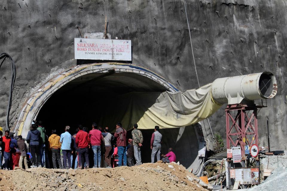 People watch rescue and relief operations at the site of an under-construction road tunnel that collapsed in mountainous Uttarakhand state, India, on Wednesday. Rescuers have been trying to drill wide pipes through excavated rubble to create a passage to free 40 construction workers trapped since Sunday. A landslide Sunday caused a portion of the 2.7-mile tunnel to collapse about 500 feet from the entrance. It is a hilly tract of land, prone to landslide and subsidence.