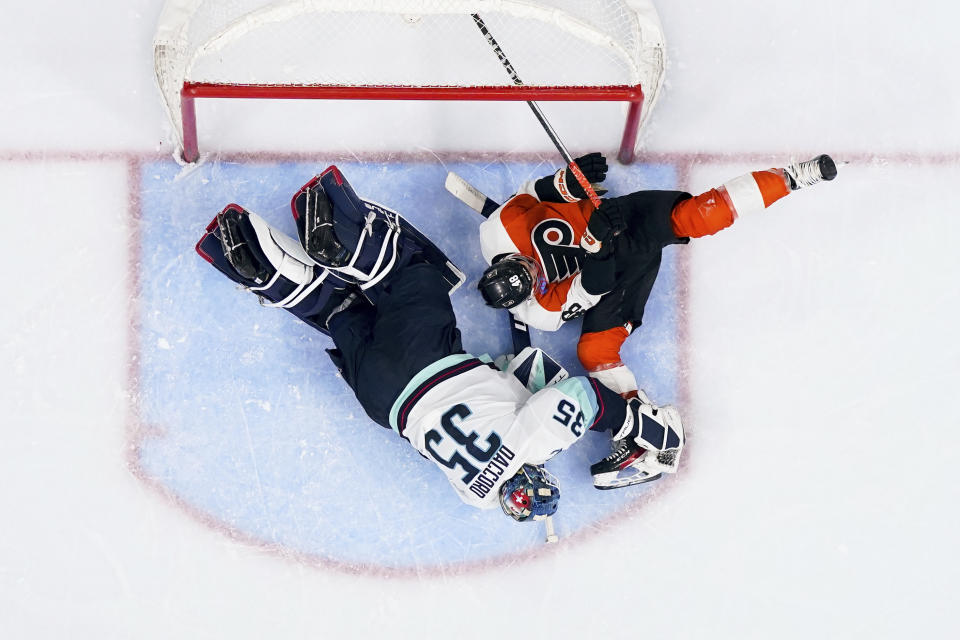 Philadelphia Flyers' Morgan Frost (48) crashes into Seattle Kraken goaltender Joey Daccord (35) during the second period of an NHL hockey game Saturday, Feb. 10, 2024, in Philadelphia. (AP Photo/Derik Hamilton)