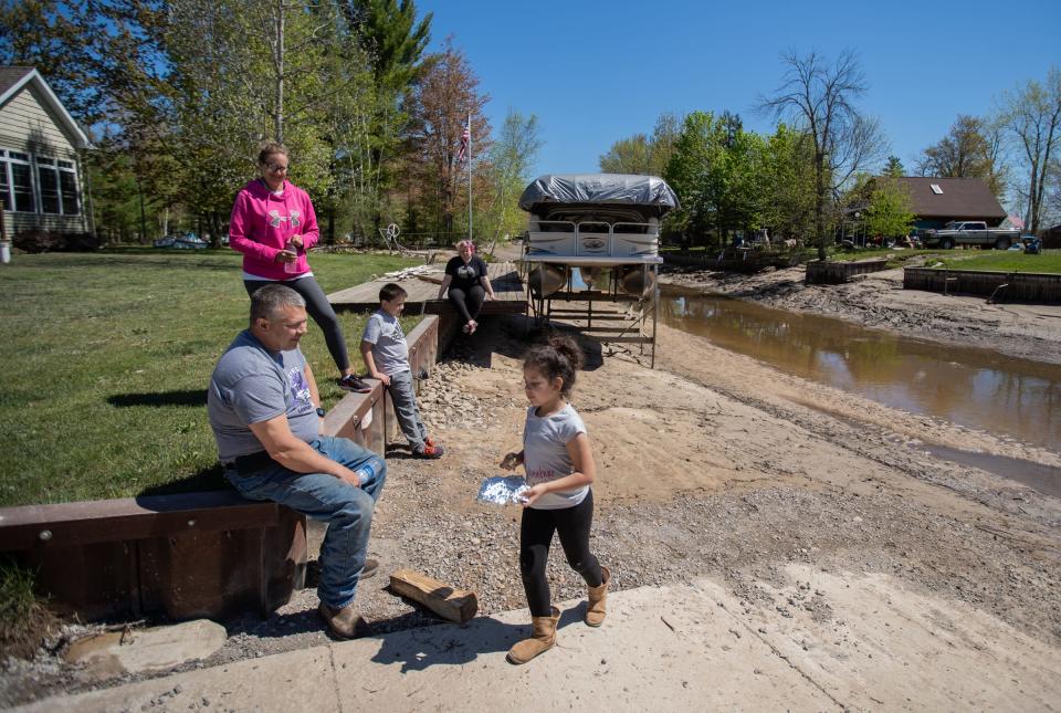 Mike Desco of Billings. Mich., and his wife, Jenn, Desco sit alongside a drained Wixom Lake in Beaverton on May 21 with Hailey Holsinger of Bay City and her brother Gabe and Juliana Stacy after heavy rain caused the Edenville and Sanford dams to fail.