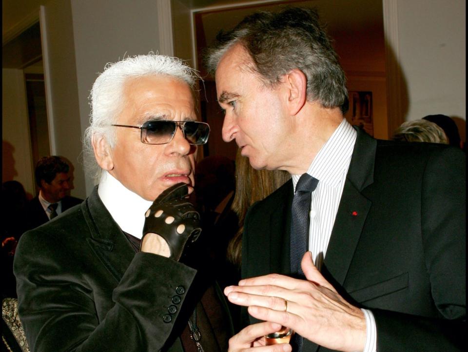 designer karl lagerfeld and bernard arnault speak at a fashion event in paris in 2005