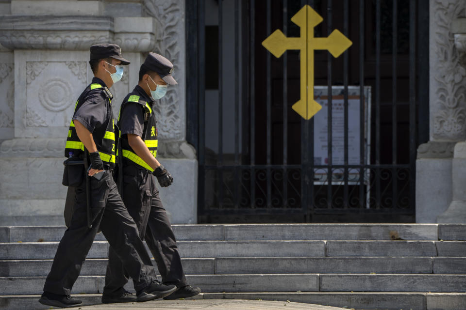 Security officers on patrol walk past the gates of the Wangfujing Church, a Catholic church in Beijing, Wednesday, Sept. 14, 2022. Chinese President Xi Jinping's first trip overseas since the early days of the COVID-19 pandemic will overlap with a visit by Pope Francis to Kazakhstan, although the Vatican says there are no plans for them to meet. (AP Photo/Mark Schiefelbein)