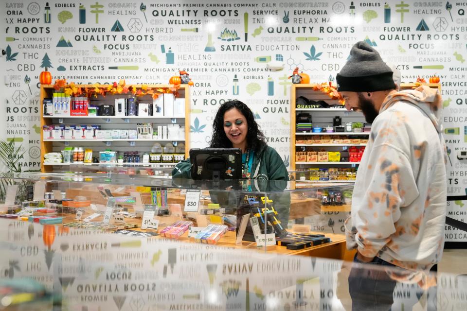 Oct 18, 2023; Monroe, Michigan, USA; AJ Harrell of Cincinnati shops for marijuana products with budtender Erica Sexton inside the Quality Roots Cannabis Dispensary in Monroe. A large number of Ohioans shop for recreational marijuana in Michigan since the state voted to legalize it in 2018. State Issue 2 on the November ballot could give them options to purchase weed products closer to home if it passes.