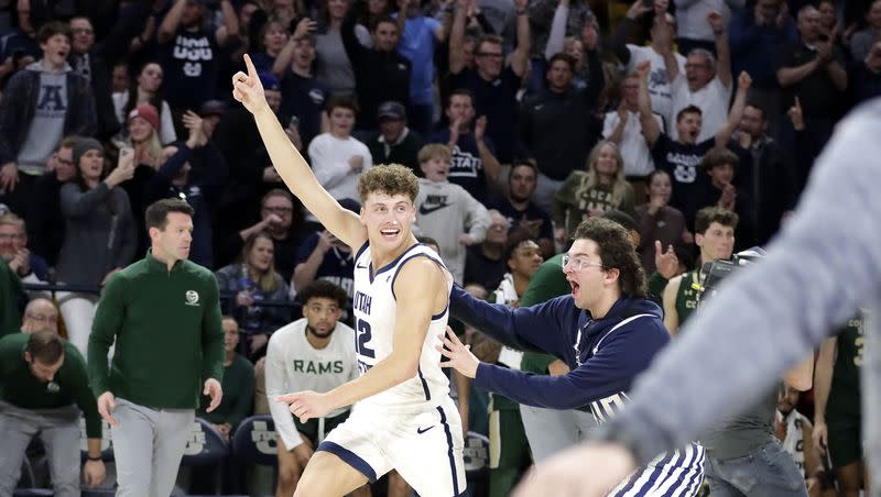 A Utah State fan runs onto the court to celebrate the Aggies’ win over No. 13 Colorado State with freshman guard Mason Falslev Jan. 6, at the Spectrum in Logan.