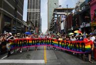 Revellers hold a banner as they participate in the" WorldPride" gay pride Parade in Toronto June 29, 2014. Toronto is hosting WorldPride, a week-long event that celebrates the lesbian, gay, bisexual and transgender (LGBT) community. REUTERS/Mark Blinch (CANADA - Tags: SOCIETY)