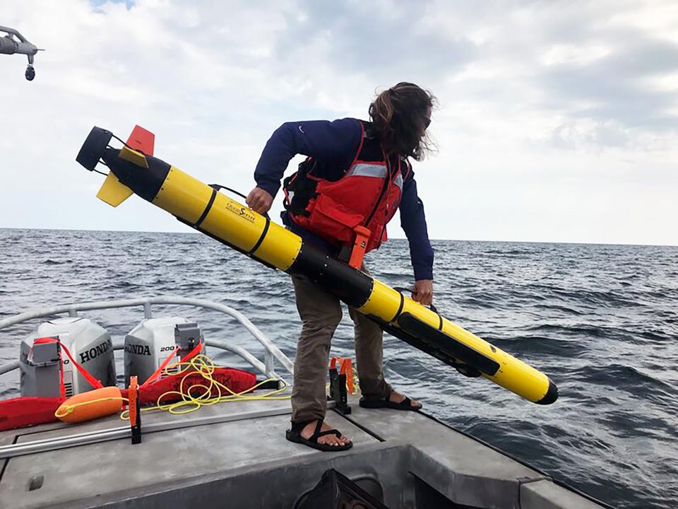 A University of Delaware student prepares to deploy an autonomous underwater vehicle in the Wisconsin Shipwreck Coast National Marine Sanctuary in Lake Michigan. The underwater vehicle uses sonar to collect data on what is hiding on the lakebed.