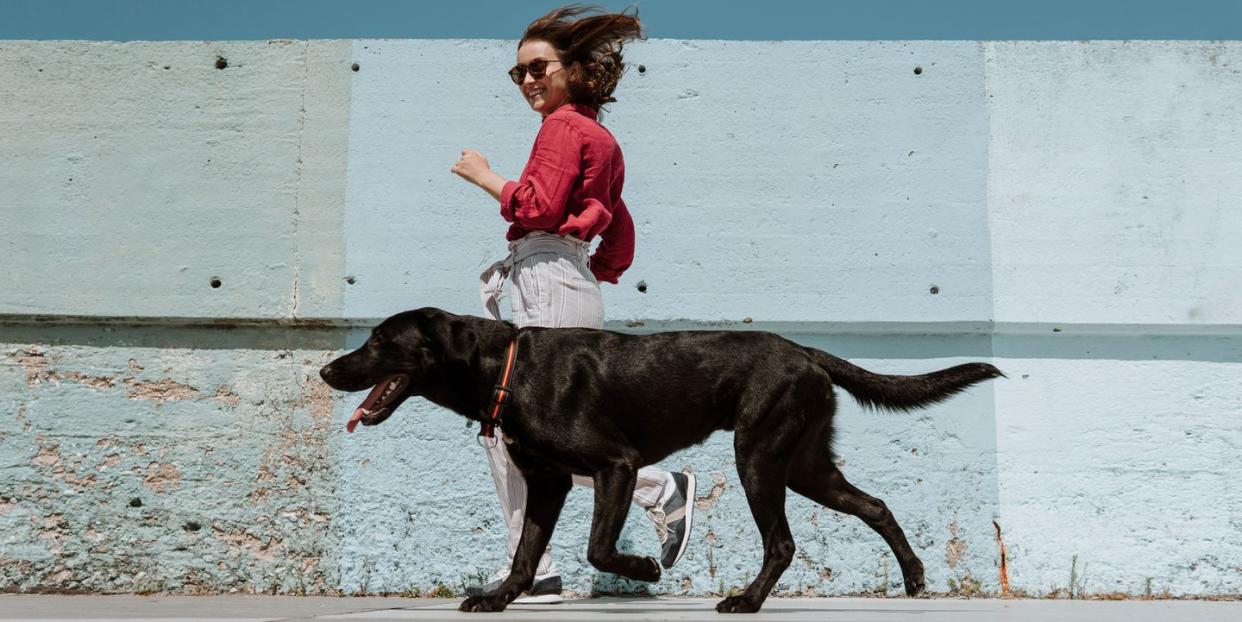 woman running alongside dog