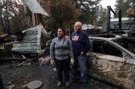 Bill Kesselring and his wife Dee stand for a portrait by the remains of their home in the aftermath of the Beachie Creek Fire near Gates, Oregon