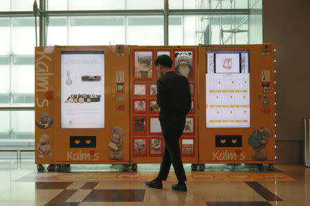 A traveller browses gifts at a vending machine by premium gift brand Kalms at Singapore’s Changi Airport Terminal 3, Singapore March 6, 2018. Picture taken March 6, 2018. REUTERS/Dewey Sim