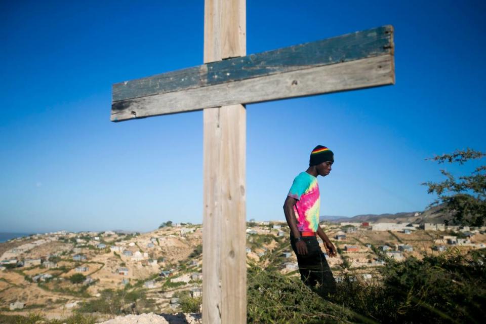 A resident walks past a cross during a memorial service honoring the victims of the 2010 earthquake, at Titanyen, a mass burial site north of Port-au-Prince, Haiti, on Sunday, Jan. 12, 2020. Sunday marked the 10th anniversary of the devastating 7.0 magnitude earthquake that killed hundreds of thousands of people and destroyed an estimated 100,000 homes across the capital and southern Haiti.