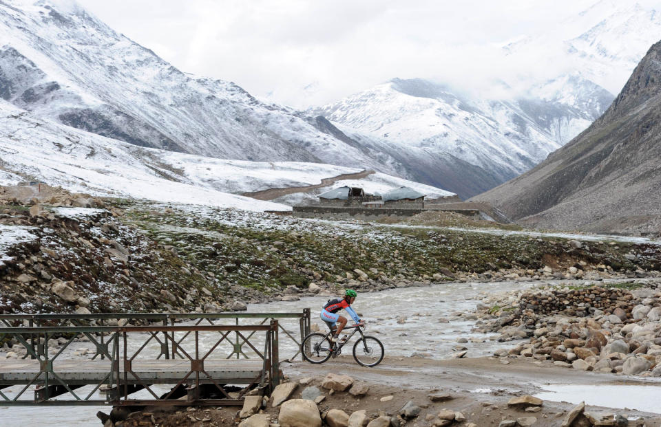 Altansukh Altanzul of World United rides during the first stage of the Himalayas 2011 International Mountainbike Race in the snow covered mountainous area of Babusar in Pakistan's tourist region of Naran in Khyber Pakhtunkhwa province on September 16, 2011. The cycling event, organised by the Kaghan Memorial Trust to raise funds for its charity school set up in the Kaghan valley for children affected in the October 2005 earthquake, attracted some 30 International and 11 Pakistani cyclists. AFP PHOTO / AAMIR QURESHI (Photo credit should read AAMIR QURESHI/AFP/Getty Images)