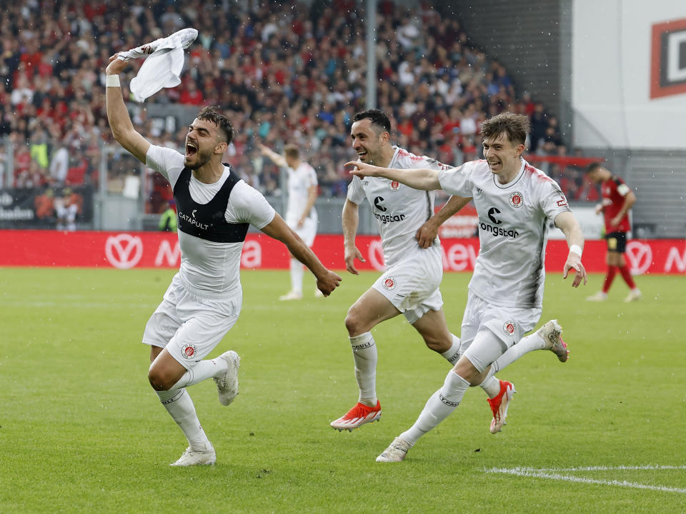 St. Pauli's Danel Sinani, left, celebrates after his goal to make it 1-2 over Wehen Wiesbaden, Germany, during their German second division soccer match Sunday, May 19, 2024 .(Heiko Becker/dpa via AP)
