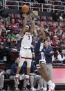 Stanford guard Kanaan Carlyle (3) takes a 3-point shot over Arizona guard KJ Lewis (5) during the first half of an NCAA college basketball game, Sunday, Dec. 31, 2023, in Stanford, Calif. (AP Photo/Tony Avelar)