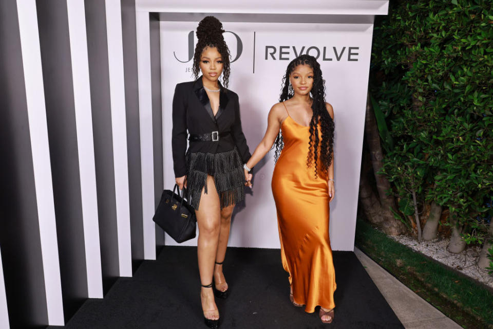 Chloe and Halle hold hands as they pose for a photo at an event
