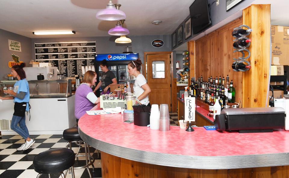 Niland's Cafe manager Kelsey Reed, right, talks to customers on Wednesday in Colo. Under Reed's management, the historic restaurant is now open for expanded hours, and the menu includes hand-cut ribeye steaks, homemade pie, breaded tenderloins, beer, wine and mixed drinks.