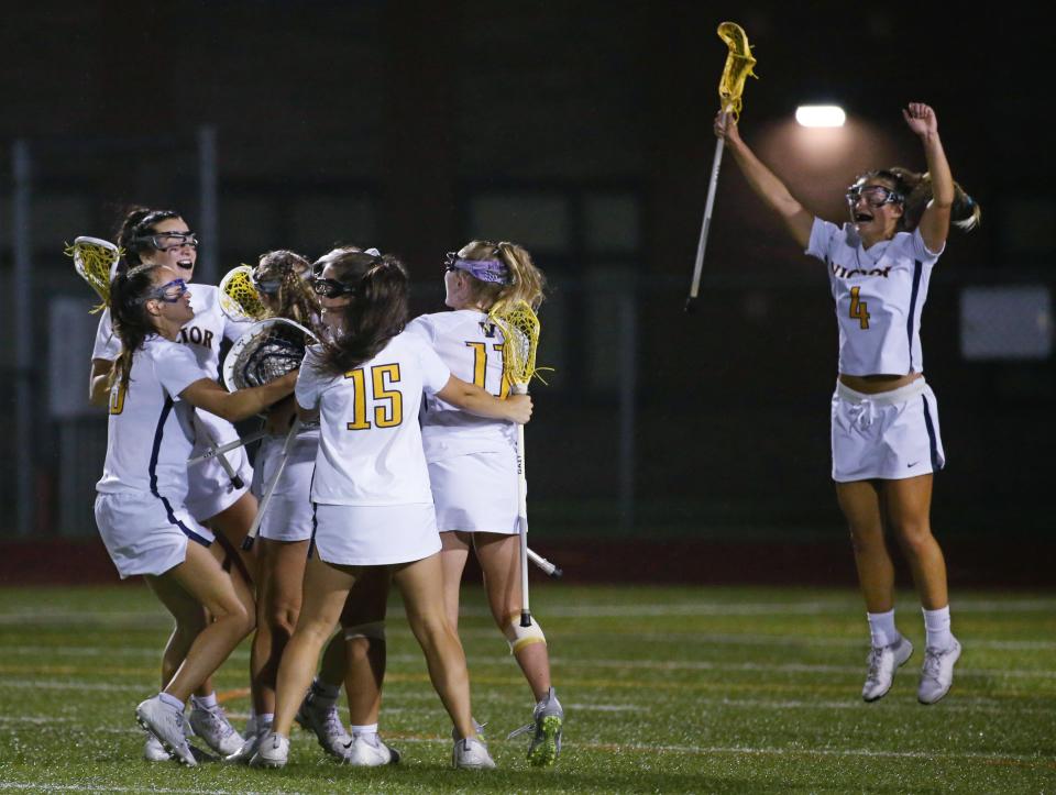 Victor players celebrate around goalie Kennedy Schottland as time expires giving them the victory in the Section V Class B girls lacrosse championship final over Canandaigua 9-5, Wednesday, June 1, 2022 at East Rochester High School. 