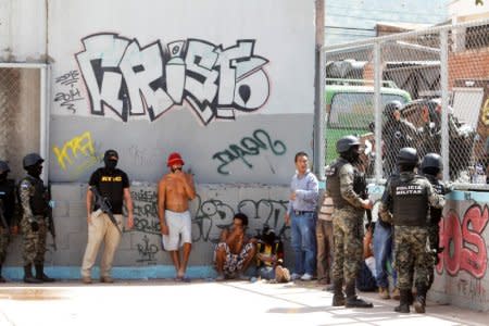 FILE PHOTO:    Military policemen keep watch on suspected MS-13 gang members detained during Operation Hunter, before taking them to police facilities for an investigation on a clandestine mass grave where the gang buried their victims, according to local media, in Tegucigalpa, Honduras, June 20, 2016. REUTERS/Jorge Cabrera/File Photo