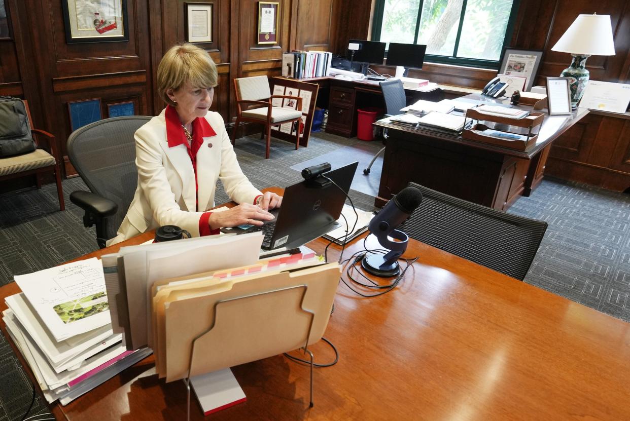 In her Bricker Hall office, Ohio State University president Kristina Johnson works at a makeshift workstation on a conference table as paperwork is piled on her desk.