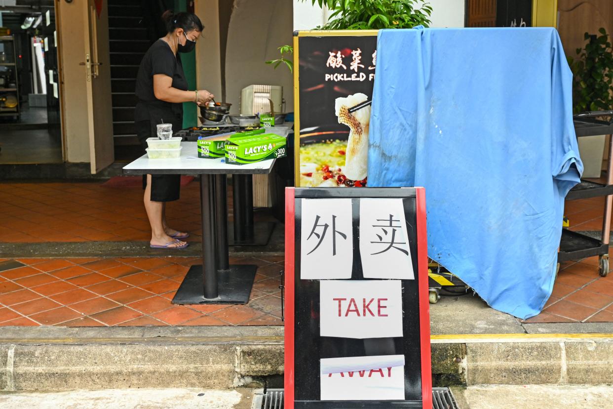 A worker prepares takeaway food orders at a restaurant along Boat Quay in Singapore on May 19, 2021, as the country increased restrictions over concerns in a rise in the number of Covid-19 coronavirus cases. (Photo by Roslan RAHMAN / AFP) (Photo by ROSLAN RAHMAN/AFP via Getty Images)