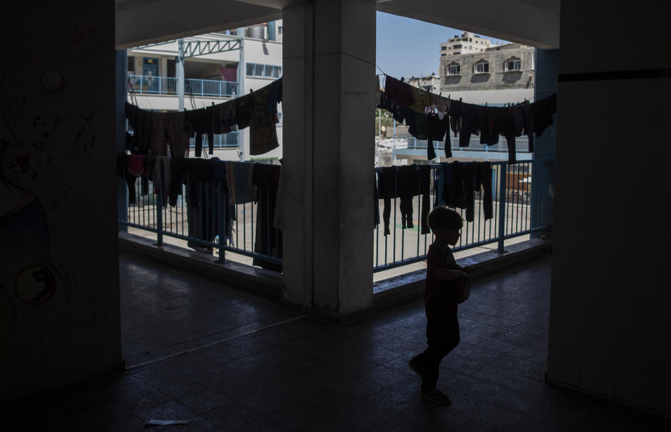 Palestinians take shelter at a school run by the U.N. after fleeing heavy Israeli missile strikes in the outskirts of Gaza City, Wednesday, May 19, 2021. The Gaza Strip's already feeble health system is being brought to its knees by the fourth war in just over a decade. At the school, no one wore a mask or could do any social distancing in the cramped quarters. (AP Photo/Khalil Hamra)